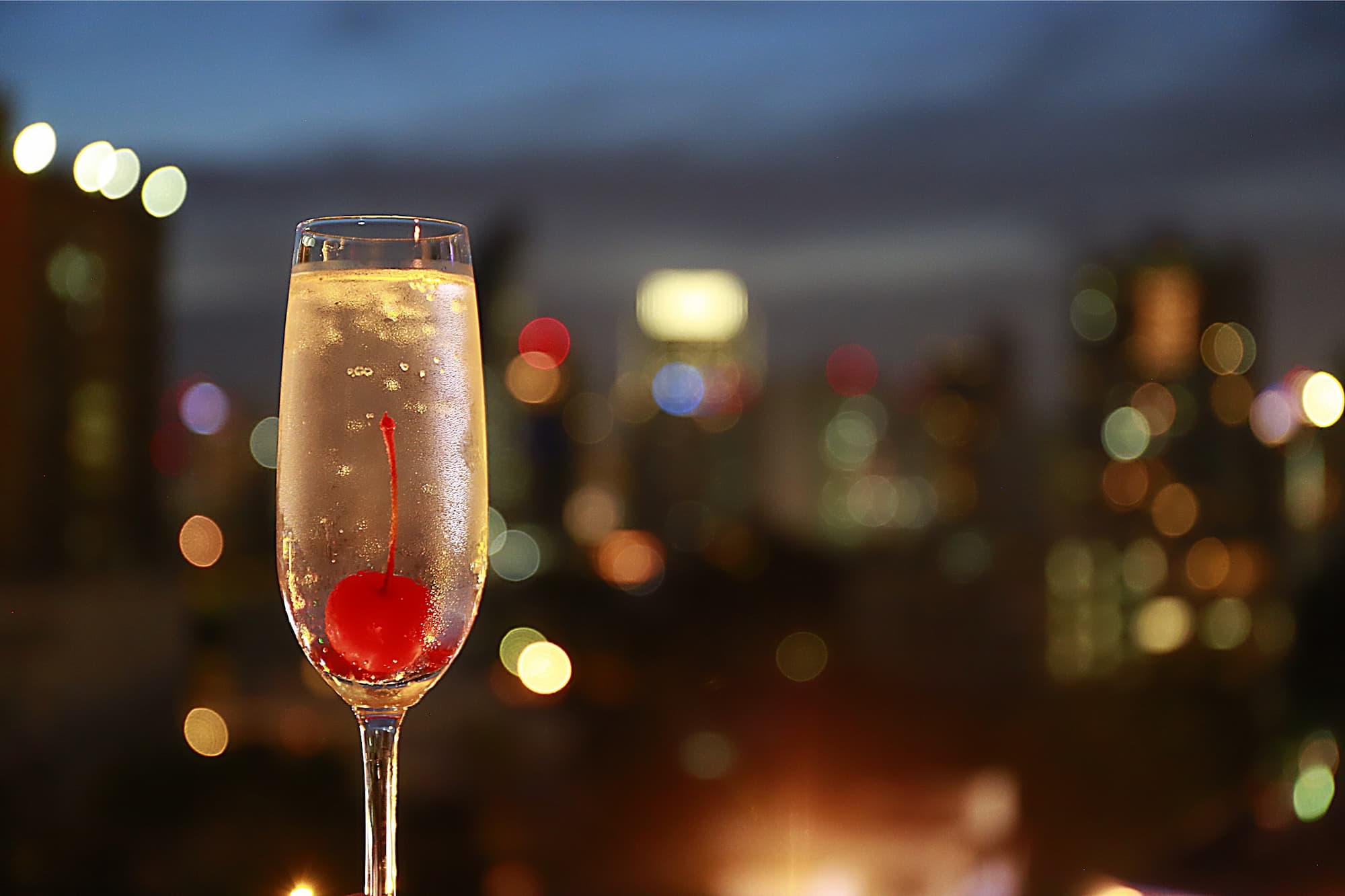 a close photo of a glass of champaign on a rooftop bar